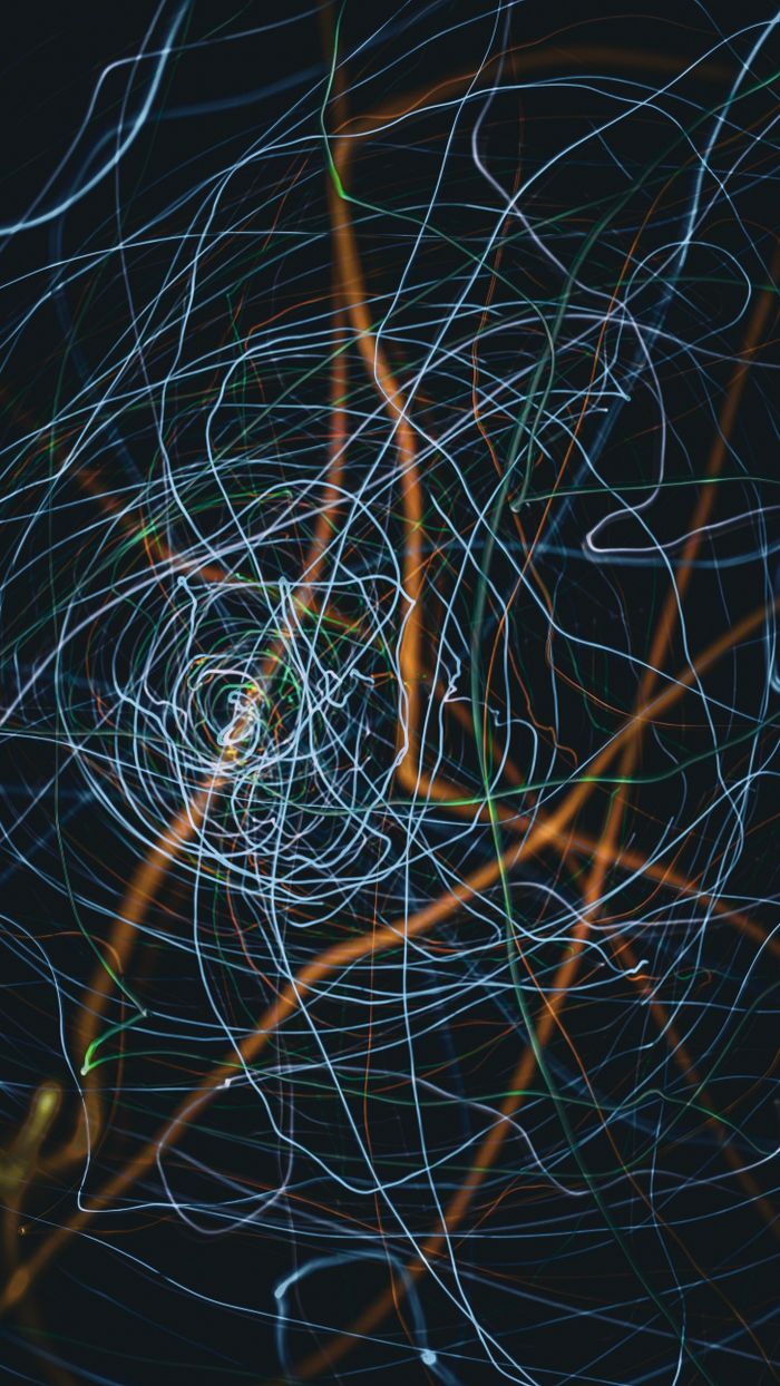 Intricate abstract light trails form a mesmerizing pattern against a black background, ideal for creative use.