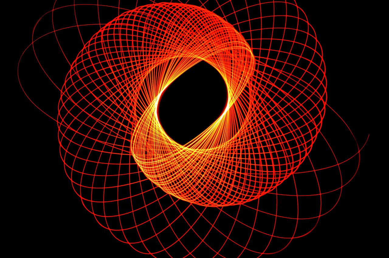 Dynamic abstract neon light pattern forming a geometric circular spiral on a black background.